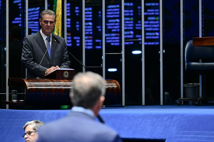 Senador Carlos Fávaro, relator do projeto, na tribuna do Plenário do Senado, observado por senadores na bancada em primeiro plano